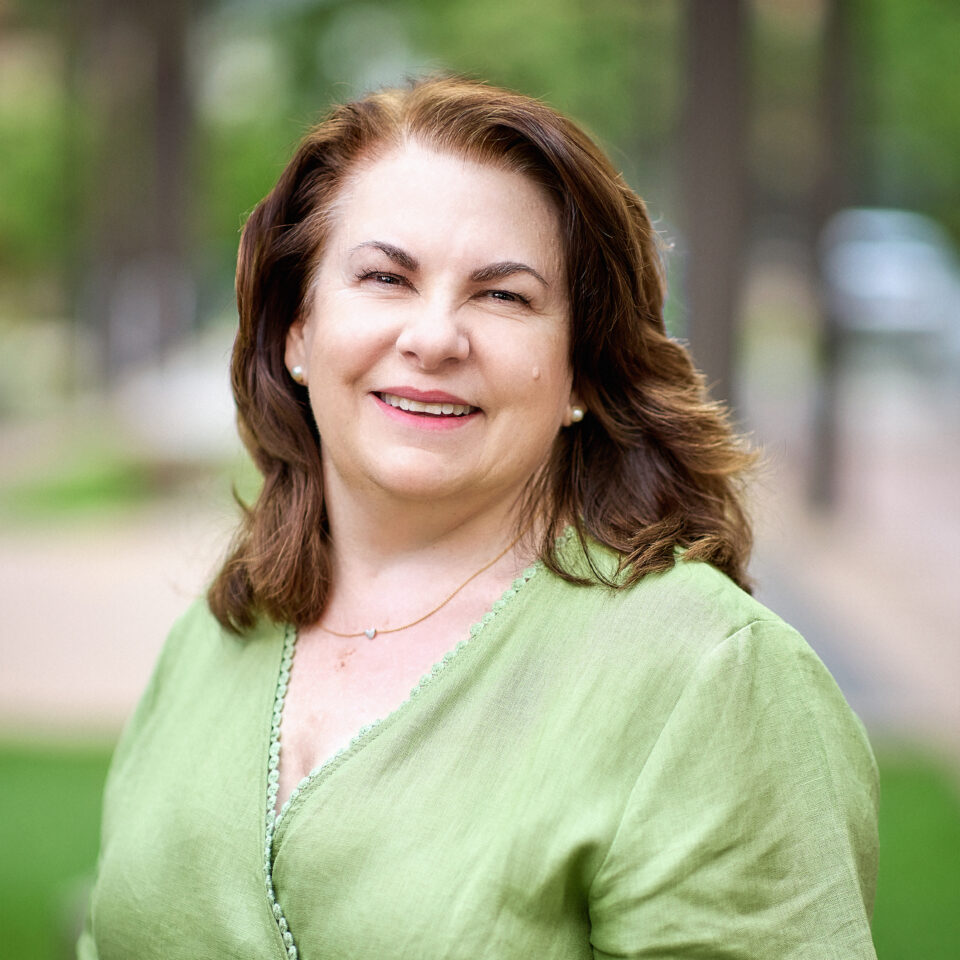 Debria Prior Headshot - Debra wears a green top and has brown hair