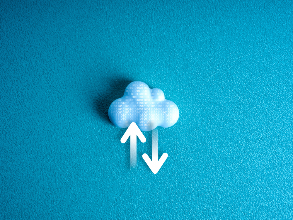 "White cloud icon with binary code on a blue background, featuring upward and downward arrows to represent cloud computing and data transfer."