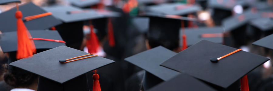 Several black graduation caps with tassels