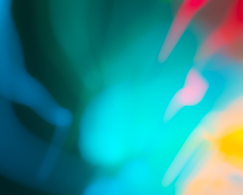 "Abstract blurred background with a smooth gradient of vibrant colors including blue, green, red, pink, and yellow."