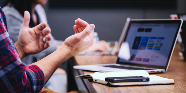 Hands near an open laptop - higher education