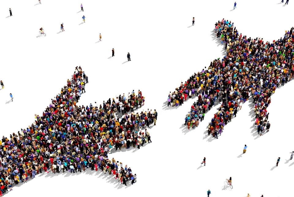 two large hands made up of groups of people reaching out to each other, taken from above