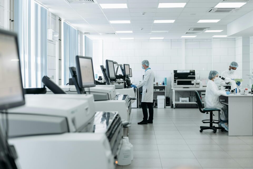 Scientific lab with people in lab coats and masks working on experiments
