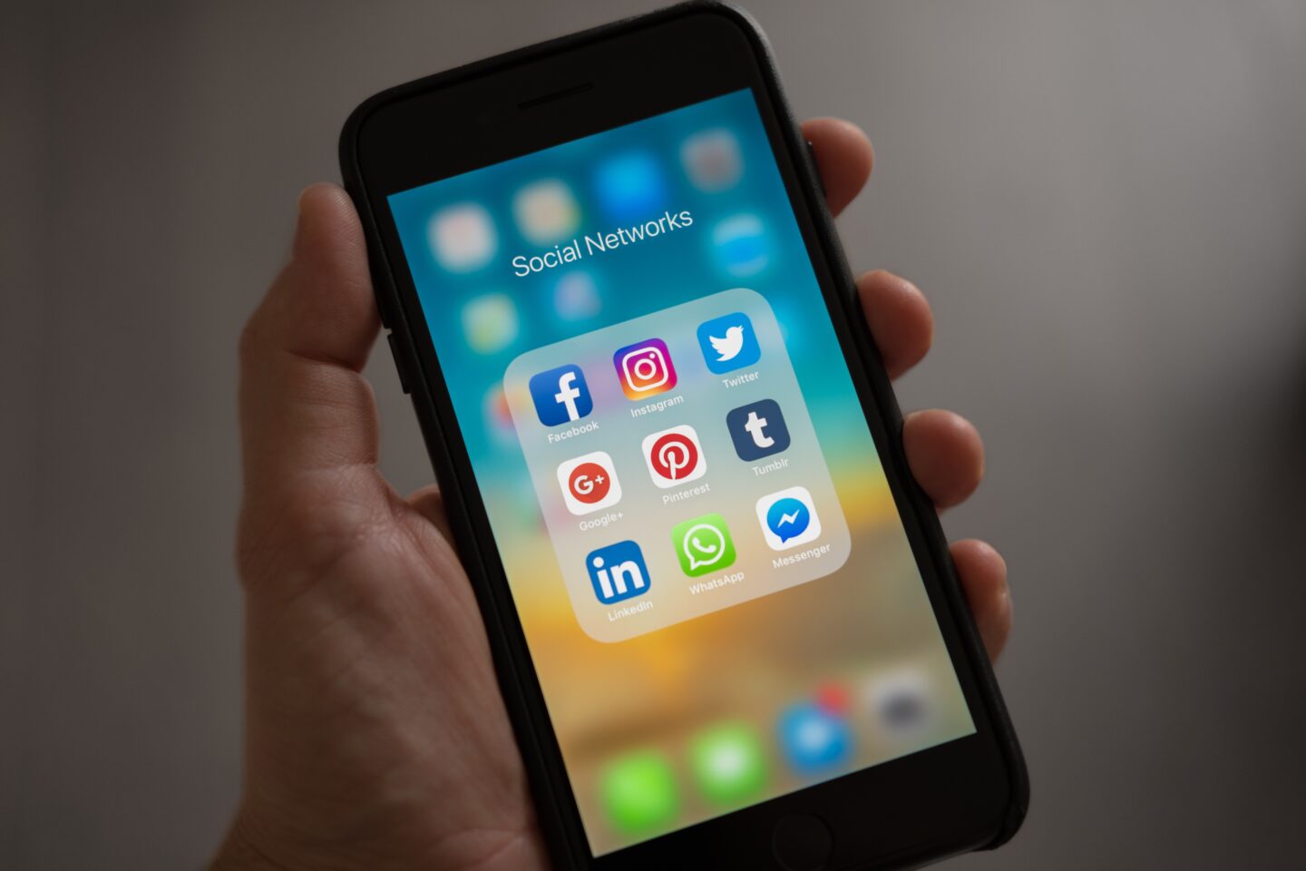 "Smartphone screen displaying a folder labeled 'Social Networks' with icons for Facebook, Instagram, Twitter, Google+, Pinterest, Tumblr, LinkedIn, WhatsApp, and Messenger."