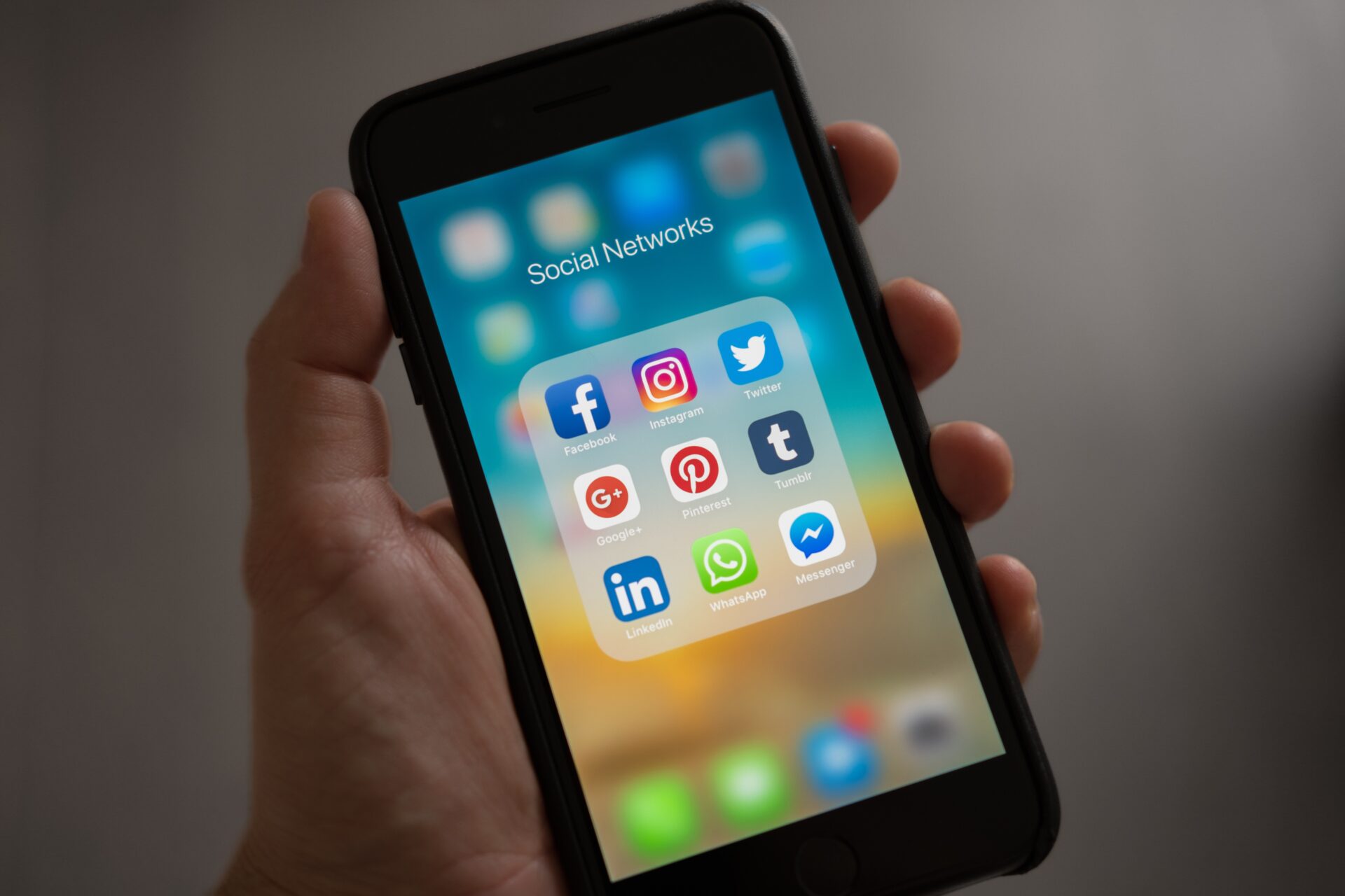 "Smartphone screen displaying a folder labeled 'Social Networks' with icons for Facebook, Instagram, Twitter, Google+, Pinterest, Tumblr, LinkedIn, WhatsApp, and Messenger."
