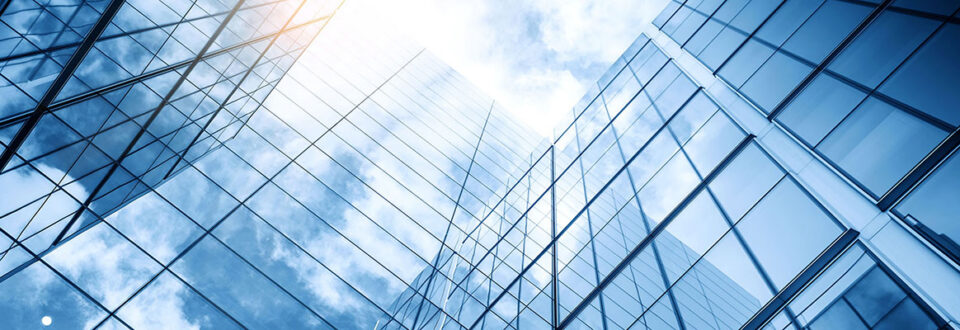Glass covered building reflecting clouds