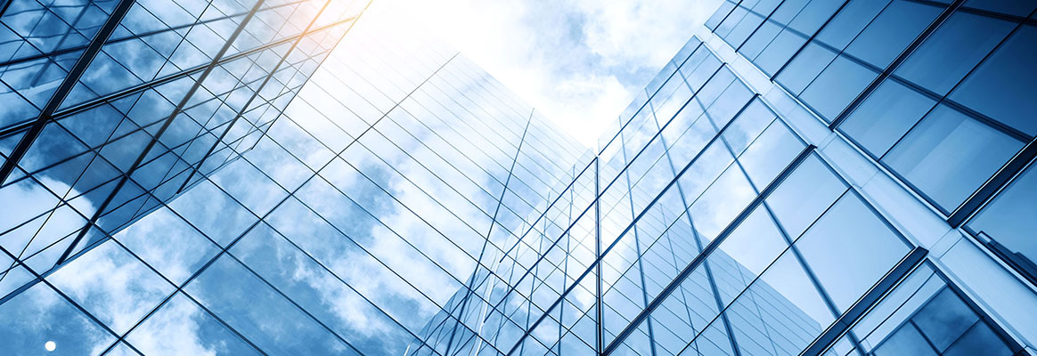 Glass covered building reflecting clouds