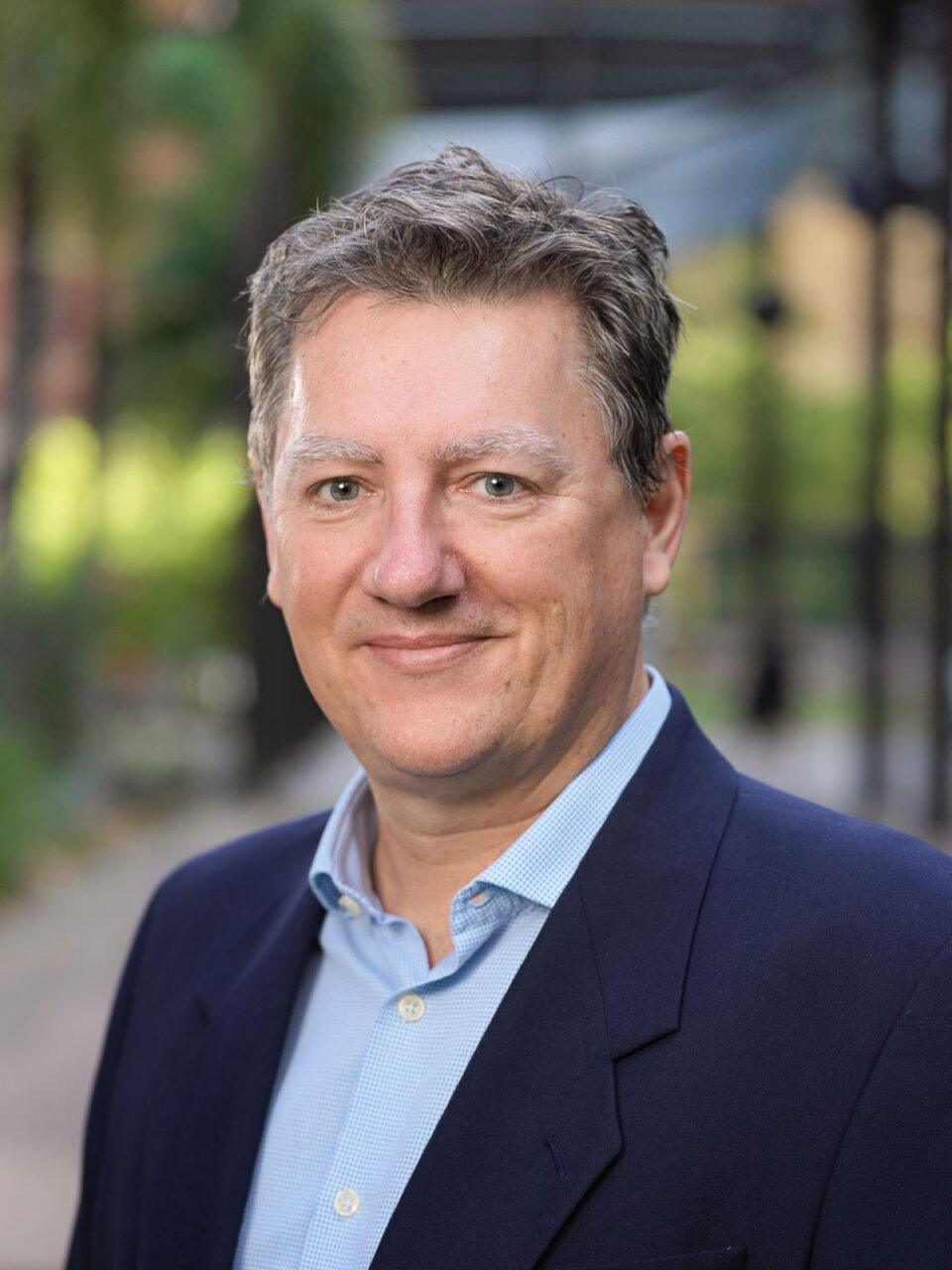 Tom Magarey Headshot - Tom wears a blue short and has a blue jacket